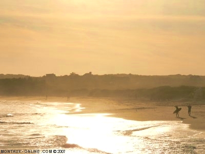 Surfers walking down the beach in the afternoon at Ditch Plains in Montauk